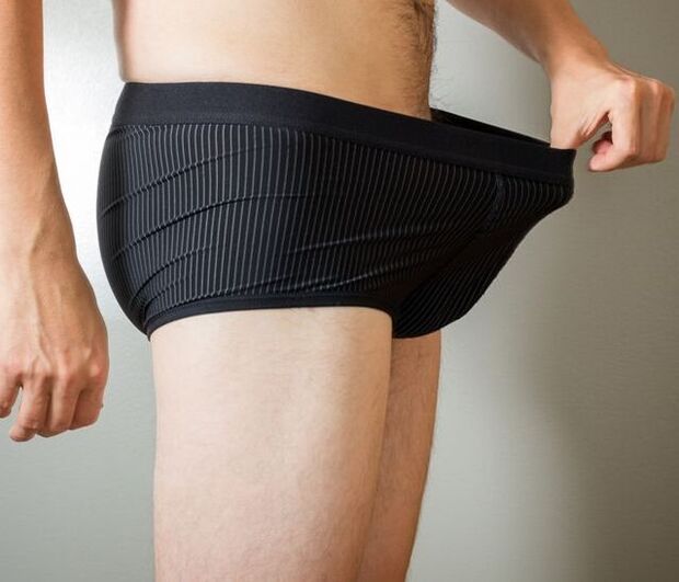 Ein Mann blickt nach einer Penisvergrößerungsoperation auf seine Boxershorts.